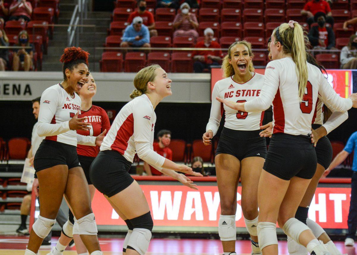 Junior defensive specialist Hannah Wander high fives freshman setter Maggie Jones as the Wolfpack celebrates a point scored against the Bulldogs in the game on Thursday, Sep. 16, 2021 in Reynolds Coliseum. Wander had 11 digs against Georgia. The Wolfpack beat the Bulldogs 3-1.
