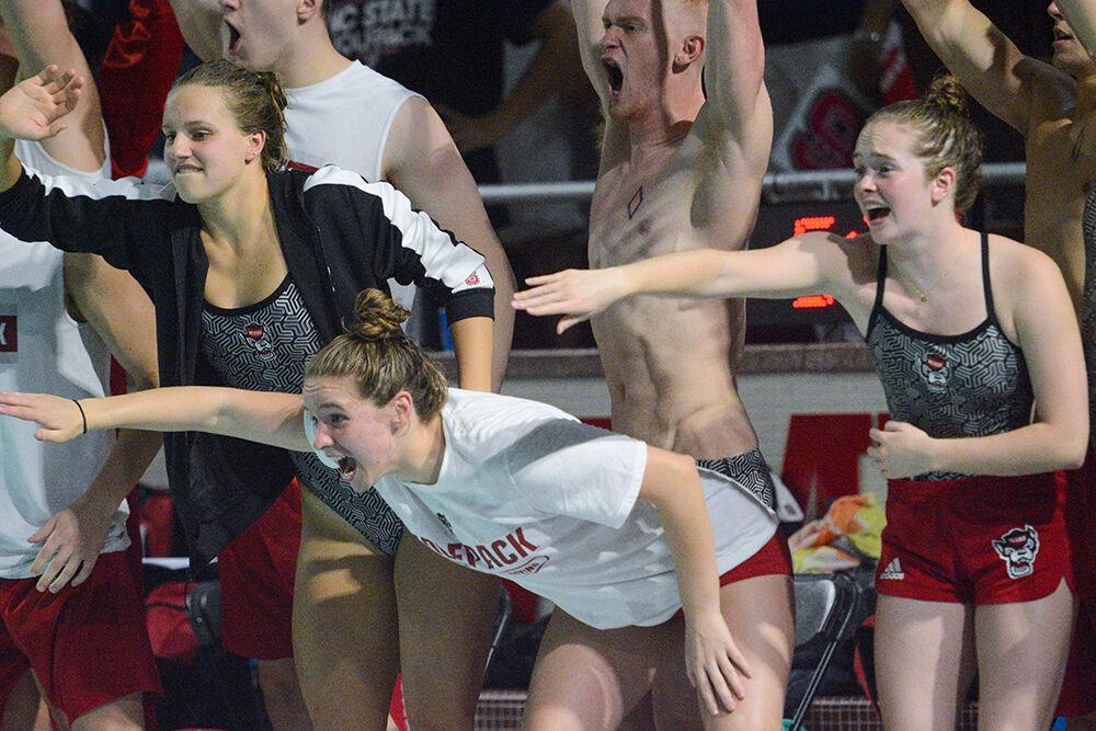 Teammates, from left, junior Elle Giesler, sophomore Abby Arens, sophomore Ashton Zuberg, cheer on their Wolfpack teammates competing in the men's 200 freestyle during the meet against Tennessee on Friday, Oct. 15, 2021 in the Willis R. Casey Aquatic Center. The Wolfpack men's team beat the Volunteers 205-95 and the women's team beat the Volunteers 182-118.