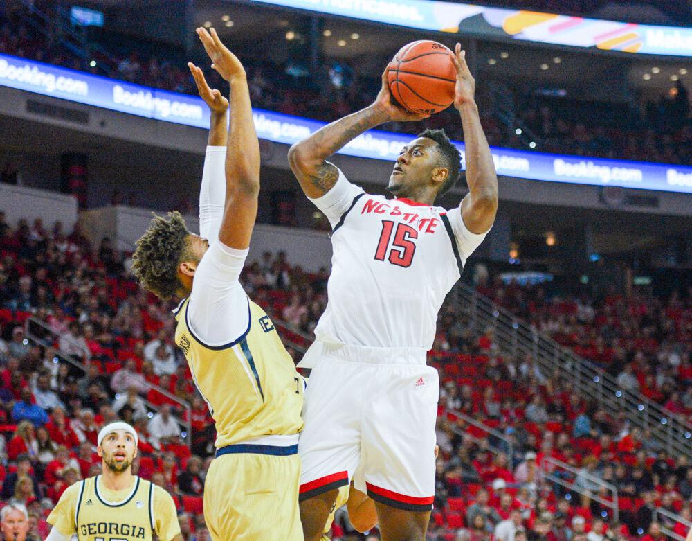 Redshirt freshman forward, Manny Bates shoots the ball over a Georgia Tech defender in PNC Arena on November 5, 2019. Bates played 33 minutes, scored two points, and had seven rebounds and five blocks in the Wolfpack&#8217;s 82-81 overtime loss to Georgia Tech.