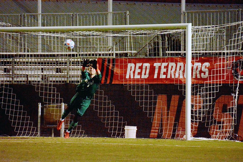 Senior goalkeeper Leon Krapf makes a save off of a Knight's free kick to keep the one goal lead during the NC State Wolfpack's soccer match against the UCF Knights at Dail Soccer Field on Monday, Sep. 6, 2021. The Wolfpack won the match 2-1.