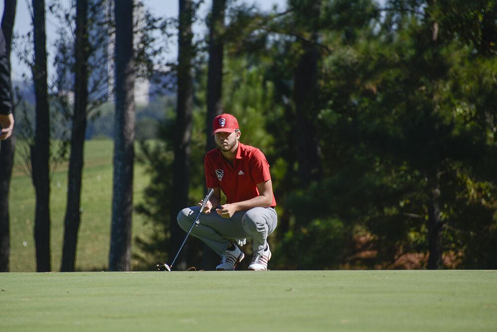 Redshirt freshman Jake Herring reads the green as he gets ready for his putt during the Wolfpack Intercollegiate on Oct. 16, 2021 at Lonnie Poole Golf Course. Herring tied for 19th overall at one-under.&#160;The NC State men's golf team won the tournament with a combined score of 17-under par.&#160;