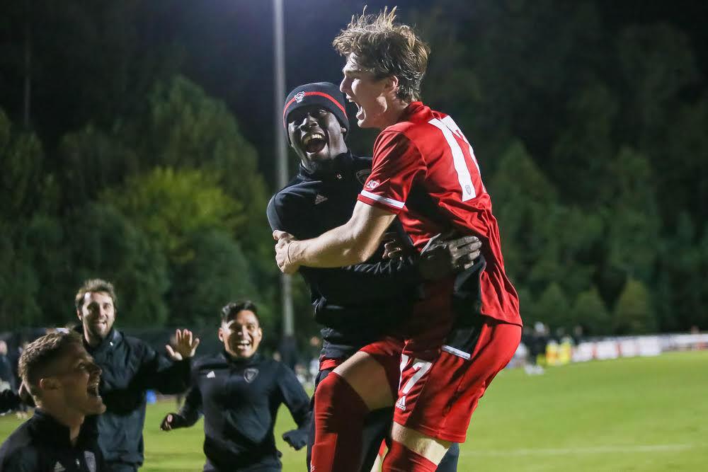 Freshman forward Luke Hille jumps into a teammates after scoring the game winner in the second overtime period to take the 1-0 win over Boston College in Dail Soccer Stadium on Friday, Oct. 29, 2021.