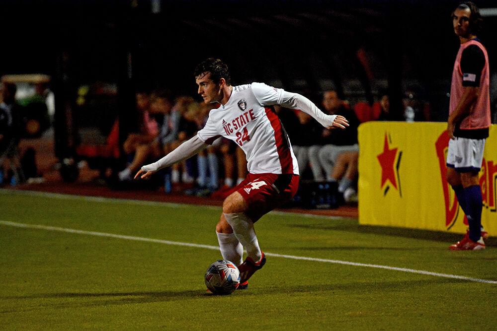 Junior defender Cam Murray dribbles the ball in NC State's game against High Point on Tuesday, Oct. 12, 2021 at Dail Soccer Field. The Wolfpack had 13 shots with six on goal in their 4-0 win over the Panthers.