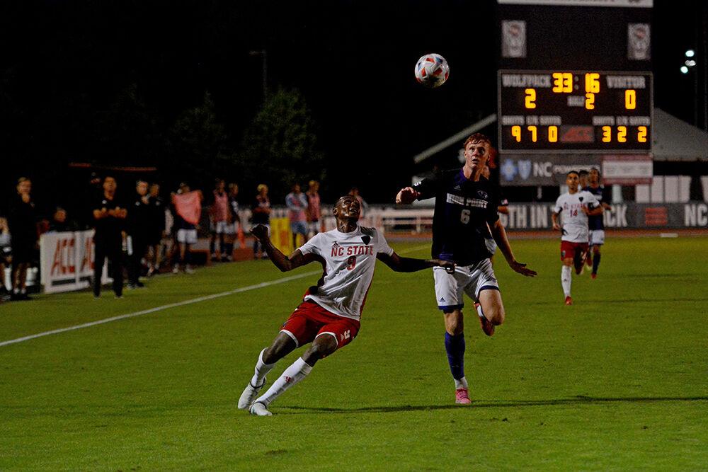 Senior forward Kuda Muskwe battles for the ball with High Point sophomore defender Finn McRobb during the game against High Point on Tuesday, Oct. 12, 2021 at Dail Soccer Field. Muskwe had two goals and one assist in the Wolfpack's 4-0 win over the Panthers.