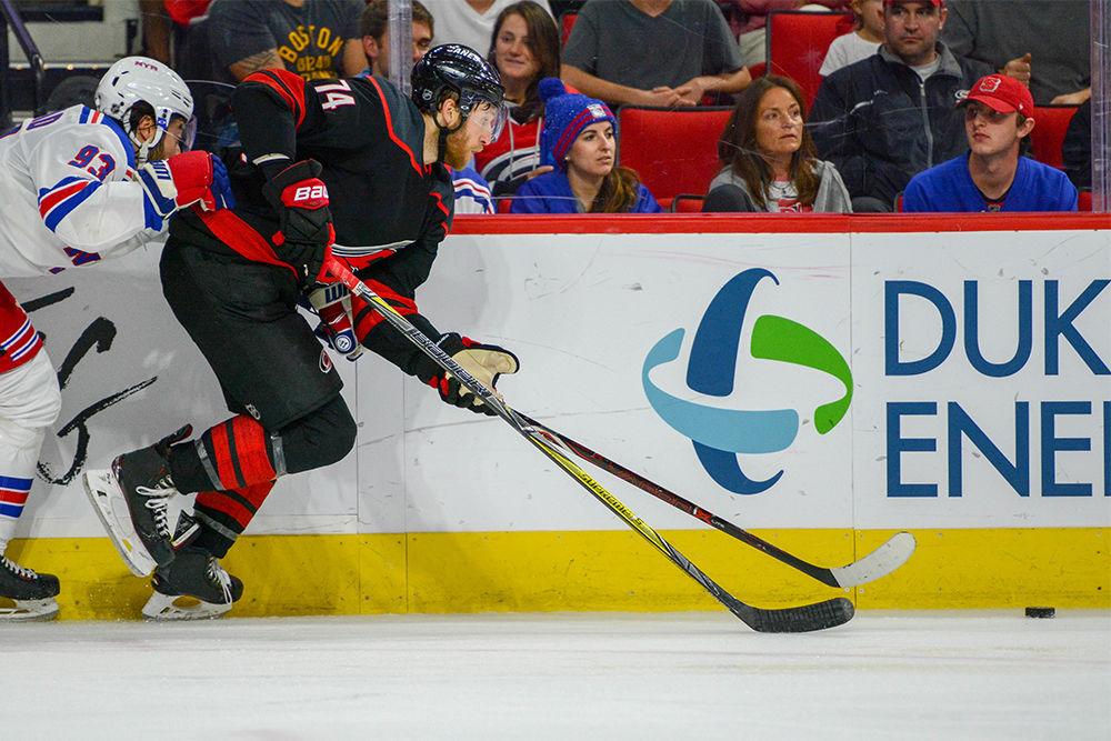 Carolina Hurricanes defender Jaccob Slavin attempts to take control of the puck during the game versus the New York Rangers on Sunday, Oct. 7, 2018 in PNC Arena. The Canes beat the Rangers 8-5.