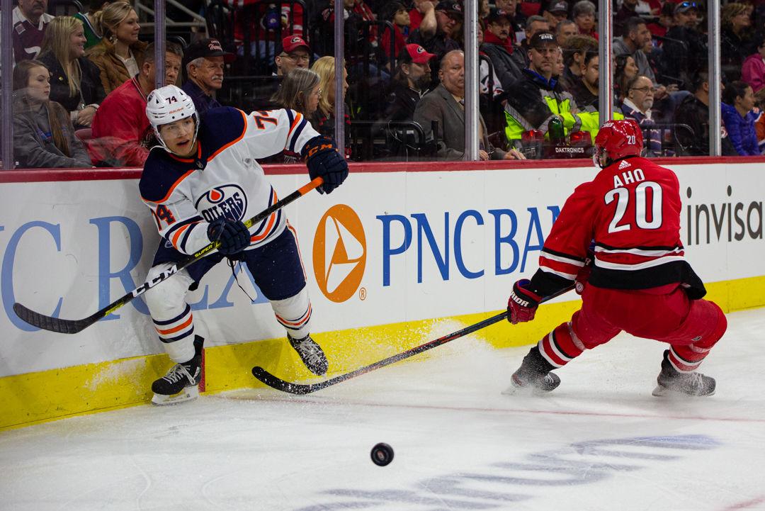 Oilers defenseman Ethan Bear clears the puck away from Hurricanes center Sebastian Aho on Sunday, Feb. 16, 2020 at PNC Arena. Bear had three shots and two hits in the 4-3 win over the Hurricanes in overtime.