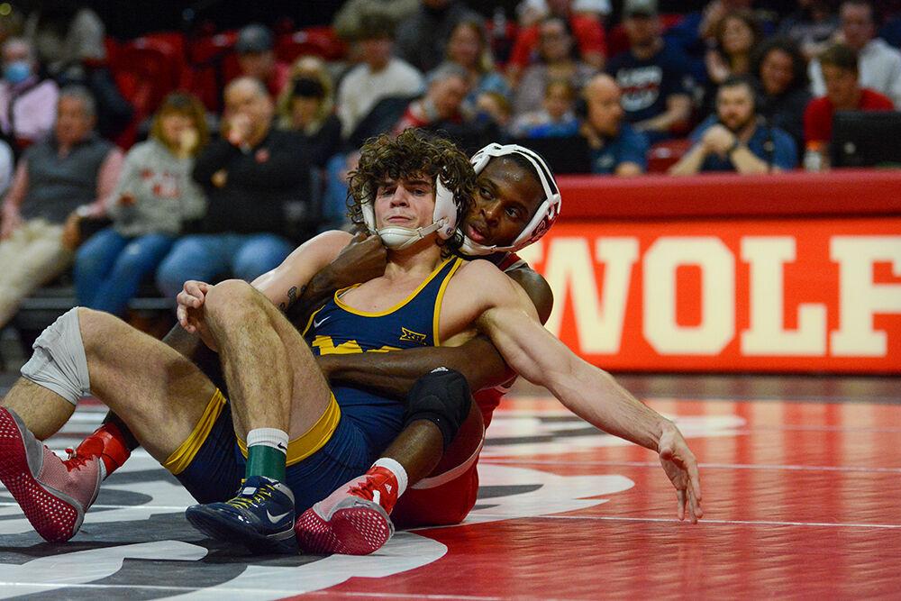 Graduate Tariq Wilson fights to maintain back control during the NC State match against West Virginia on Sunday, November 21, 2021 in Reynolds Coliseum. Wilson won his individual match against the Mountaineers 13-4. The Pack beat the Mountaineers 34-6.