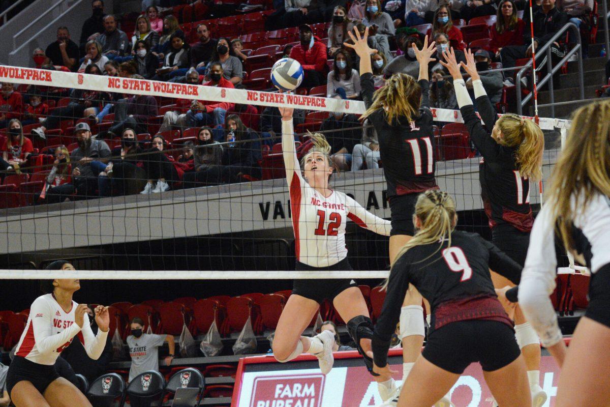 Junior opposite hitter Taylor Rowland blocks a Louisville spike on Friday, November 5, 2021 in Reynolds Coliseum. The Louisville Cardinals beat the Wolfpack 3-0.