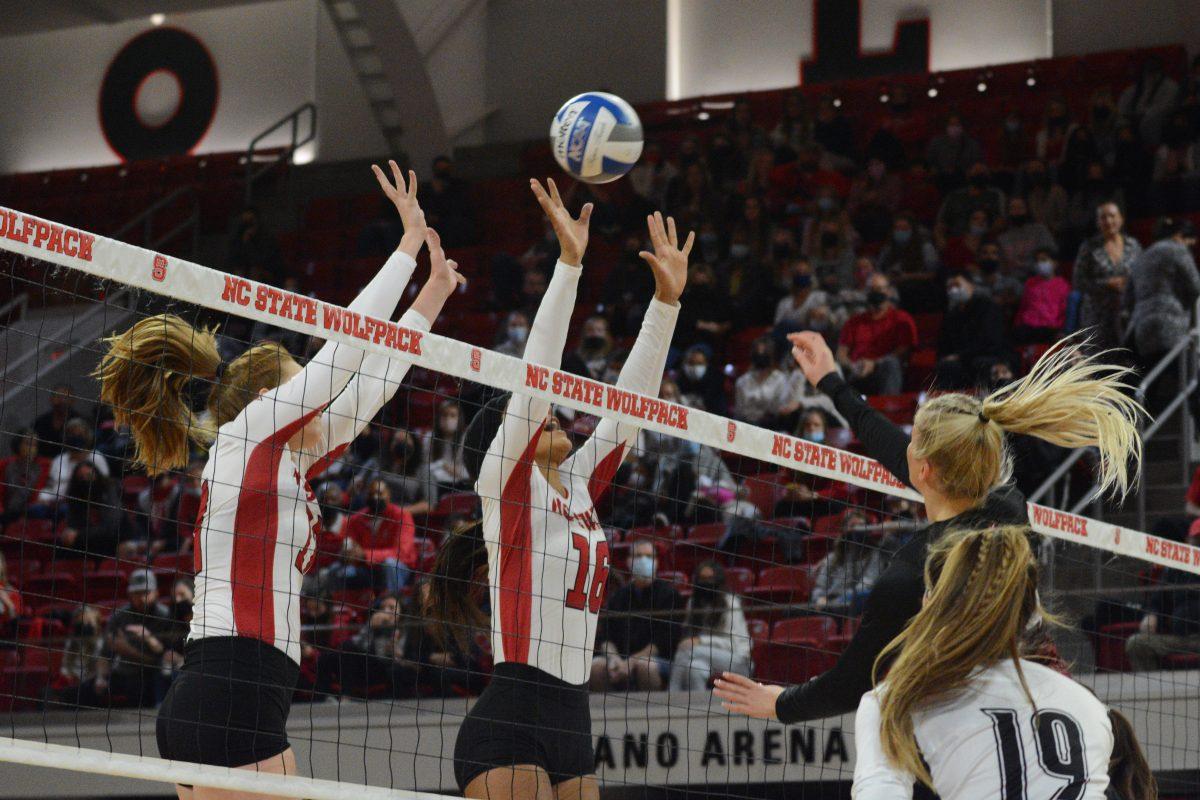 Junior setter Hannah Reid and Junior setter Kristen McDaniel look to block a Louisville spike Louisville spike on Friday, November 5, 2021 in Reynolds Coliseum. The Louisville Cardinals beat the Wolfpack 3-0.