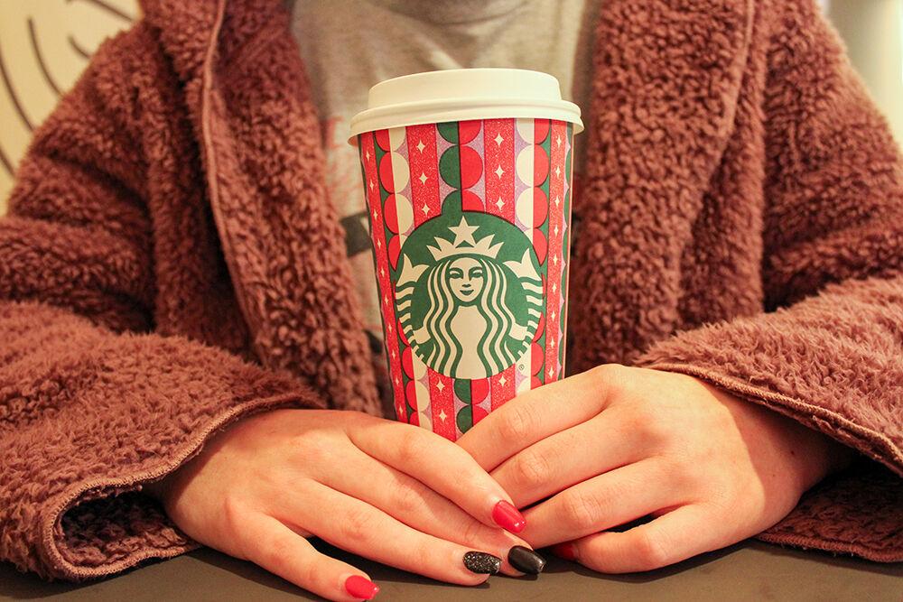 Hannah Stewart, a third-year in international studies, holds the 2021 Starbucks holiday cup at Talley Student Union on Monday, Nov. 22, 2021.