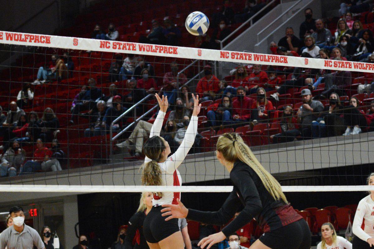 Junior setter Kristen McDaniel leaps to block a Louisville spike on Friday, November 5, 2021 in Reynolds Coliseum. The Louisville Cardinals beat the Wolfpack 3-0.