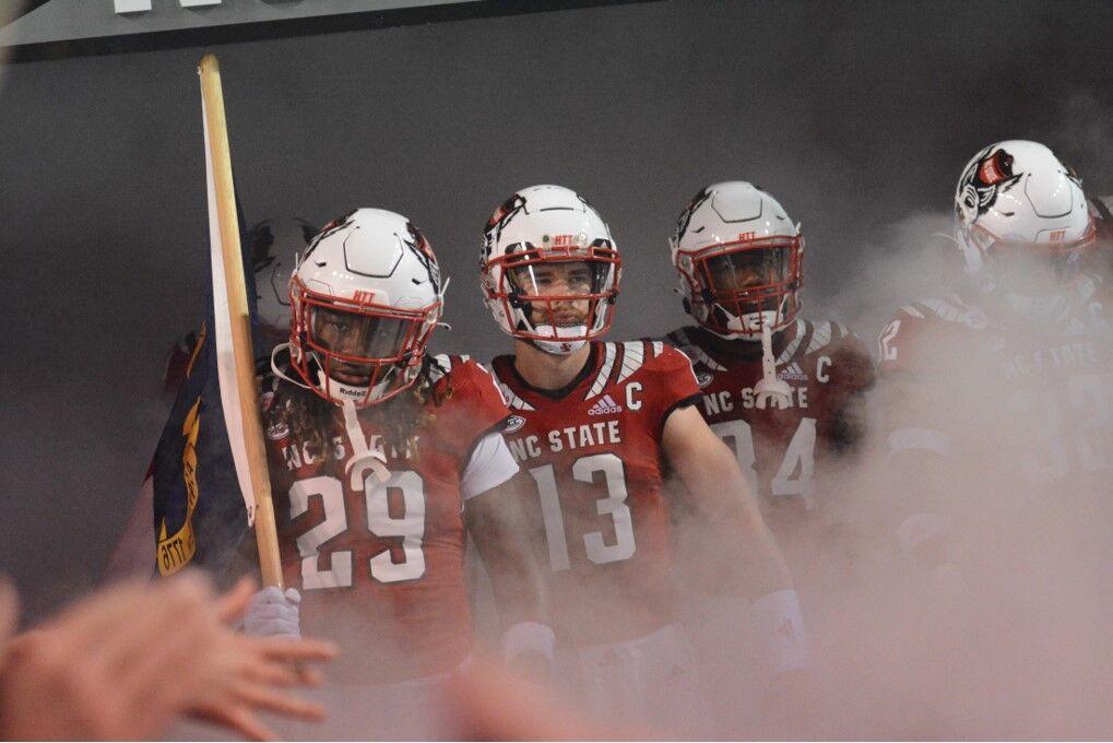 Freshman safety Sean Brown, redshirt sophomore quarterback Devin Leary and redshirt freshman running back Delbert Mimms III emerge from the tunnel at the Homecoming game against Louisville at Carter-Finley Stadium on Saturday, Oct. 30, 2021. Leary threw four touchdowns and led the Wolfpack to a 28-13 victory against the Cardinals.