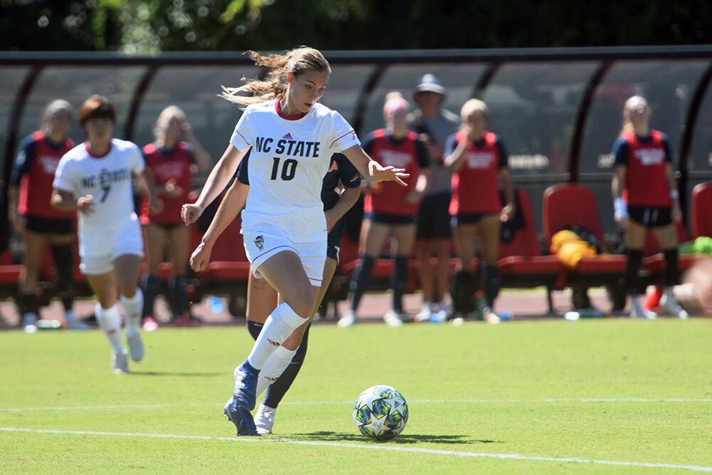 Freshman midfielder Annika Wohner dribbles the ball past a Virginia defender on Sunday, Sept. 26, 2021 at Dail Soccer Field. The Wolfpack scored one goal but lost to the Cavaliers 2-1.