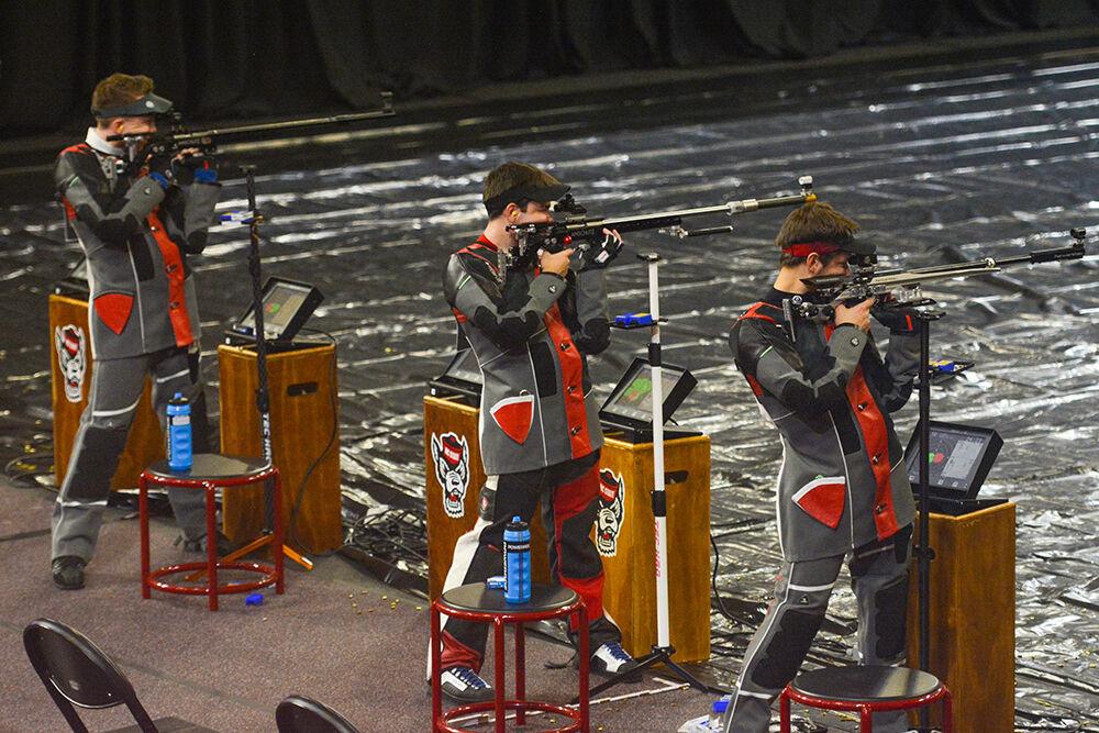 Red shirt sophomore Travis Stockton, left, sophomore Ben Salas, center, and freshman Samuel Burrow, right, aim at their respective targets at the NC State versus west Virginia rifle match at Reynolds Coliseum on Sunday. Oct. 17, 2021. NC State lost 4730-4652 against West Virginia.