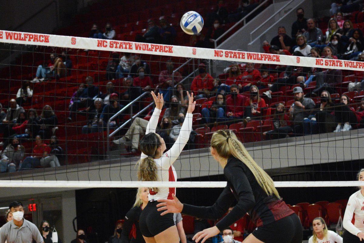 Junior setter Kristen McDaniel leaps to block a Louisville spike on Friday, November 5, 2021 in Reynolds Coliseum. The Louisville Cardinals beat the Wolfpack 3-0.