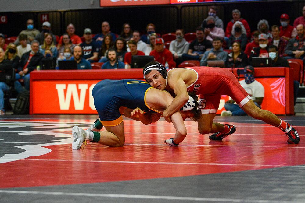 Redshirt sophomore Jakob Camacho sprawls during the NC State match against West Virginia on Sunday, November 21, 2021 in Reynolds Coliseum. Camacho won his individual match against the Mountaineers 14-4. The Pack beat the Mountaineers 34-6.