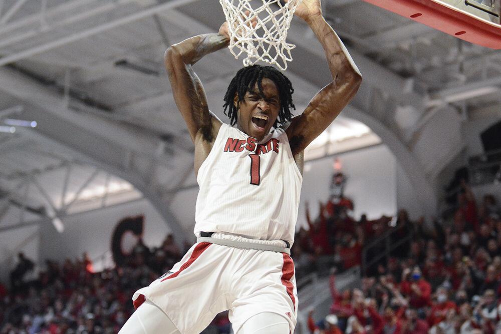 Redshirt sophomore guard Dereon Seabron celebrates while dunking the ball in the game against the Bethune-Cookman Wildcats In James T. Valvano Arena at Reynolds Coliseum on Thursday, Dec. 9, 2021. This game was the annual "Heritage Game." Seabron scored 16 points and helped with the Wolfpack win 65-48.