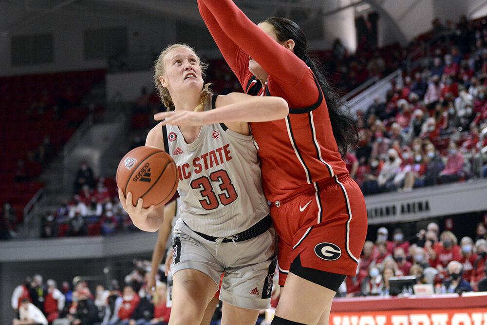 Senior center Elissa Cunane fights to put up the ball against a Georgia defender at Reynolds Coliseum on Thursday, Dec. 16, 2021. Cunane was the highest NC State scorer of the game with 20 points but the Wolfpack lost to the Bulldogs 82-80 in overtime.