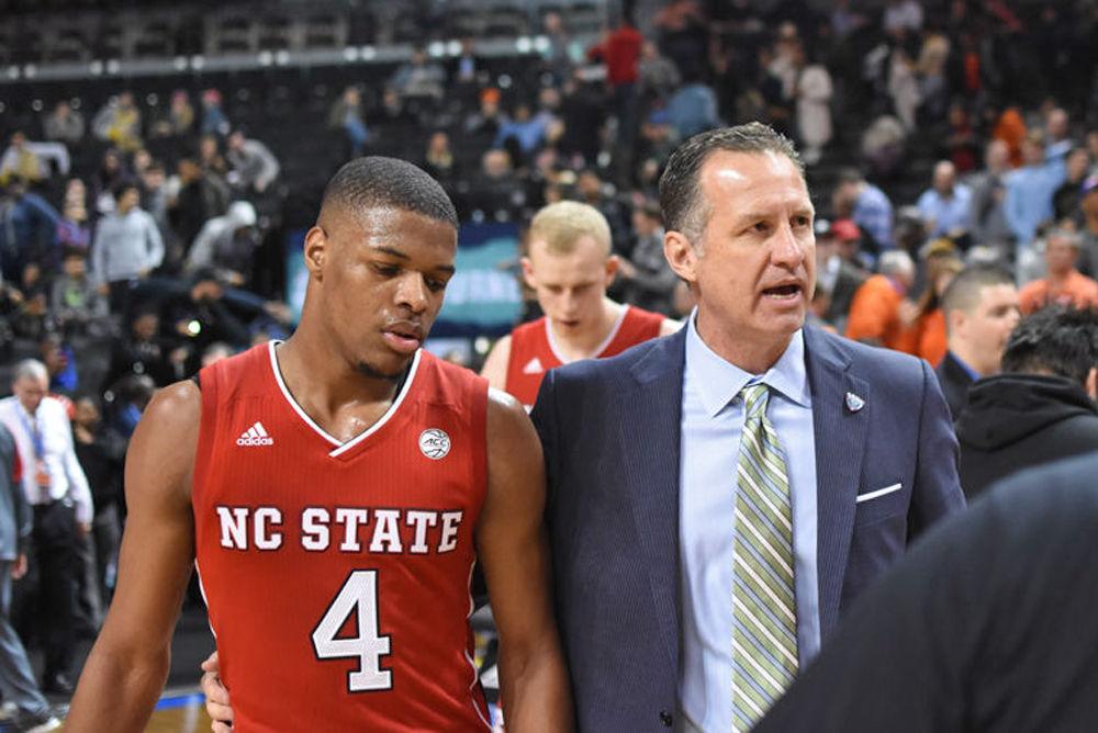 Former Head Coach Mark Gottfried walks back to the locker room with freshman guard Dennis Smith Jr. after his last game as the coach of the Wolfpack on March 7, 2017 at Barclays Center in Brooklyn. The Wolfpack was defeated by Clemson 75-61 during the first round of the 2017 ACC Men's Basketball Tournament.