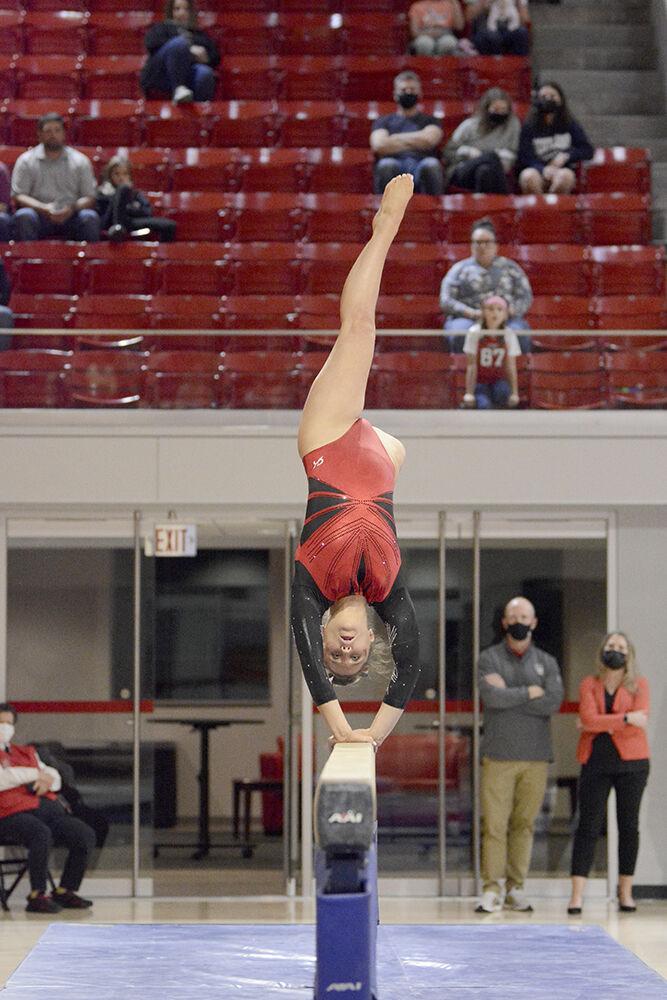 Freshman gymnast Lauren Rutherford does a back handspring on the balance beam during NC State&#8217;s Red and White Exhibition meet on Friday, Dec. 17, 2021 at Reynolds Coliseum. This preseason meet ended with the white team beating the red team 10-7.