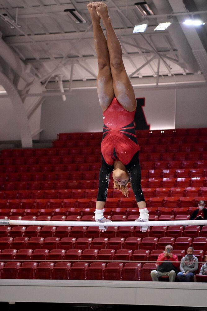 Sophomore gymnast Carina Jordan does a giant on the uneven bars at NC State&#8217;s Red and White Exhibition meet on Friday, Dec. 17, 2021 at Reynolds Coliseum. The white team beat the red team at the preseason meet 10-7.