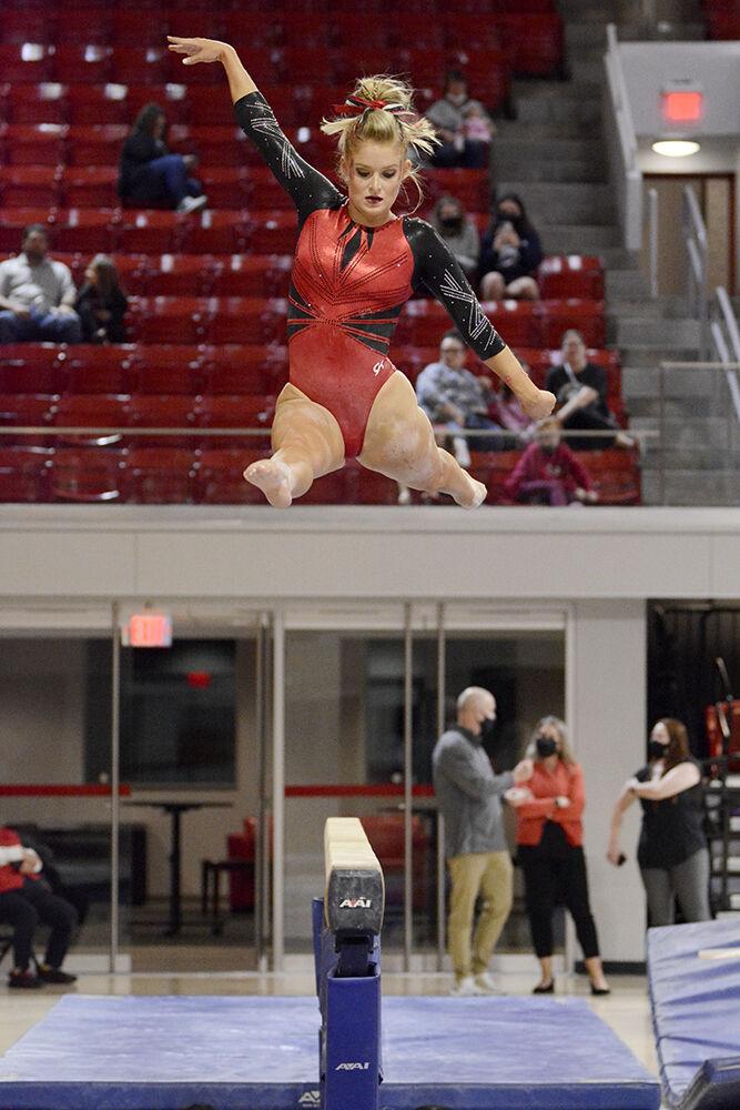 Graduate gymnast Nicole Webb leaps on the beam during the third rotation of NC State Red and White Exhibition meet. Webb was on the red team and the preseason meet ended with the white team winning 10-7.