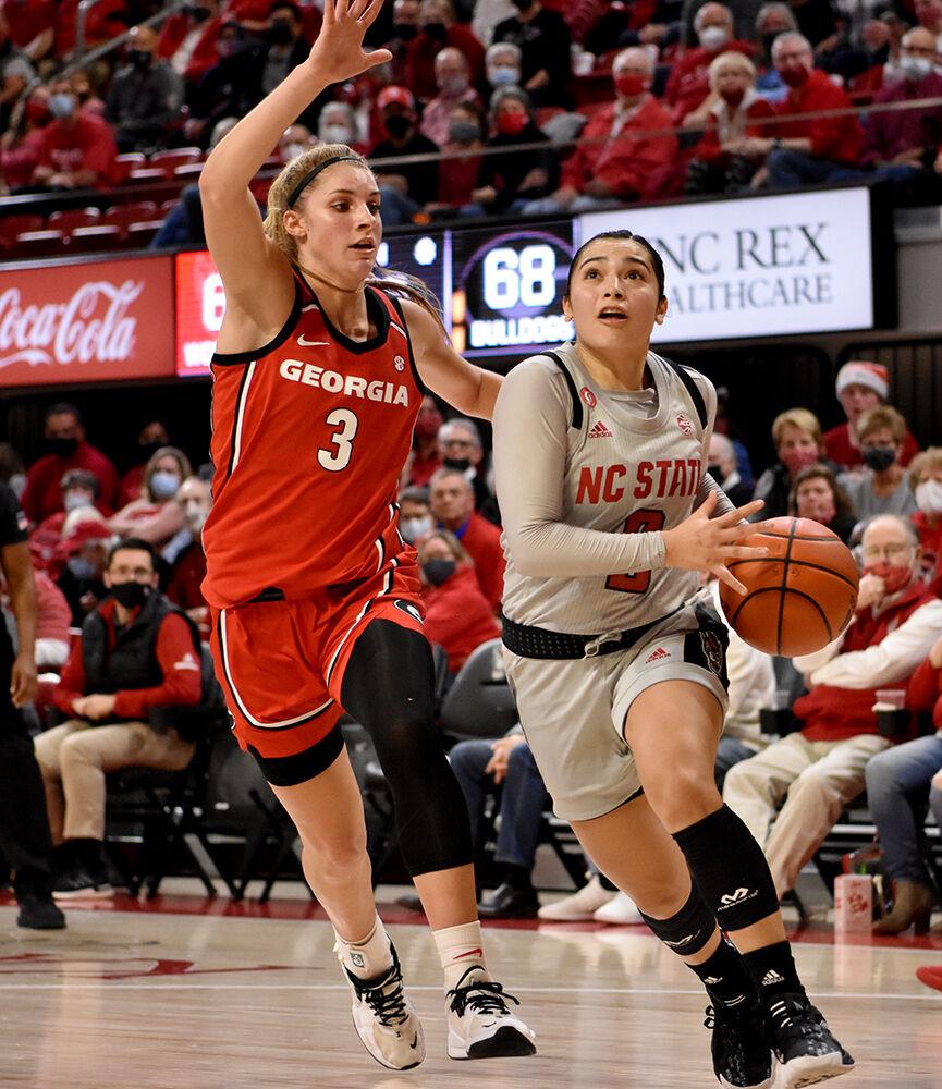 Graduate guard Raina Perez drives the ball past a Georgia defender at Reynolds Coliseum on Thursday, Dec. 16, 2021. Perez had 13 points during the game. NC State lost to Georgia 82-80.