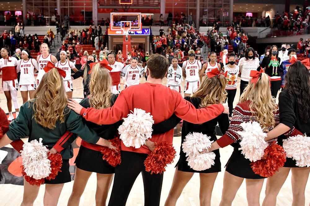 The NC State women&#8217;s basketball team and cheerleaders celebrate a victory against Virginia on Sunday, Dec, 10, 2021 at Reynolds Coliseum. NC State beat Virginia 82-55.