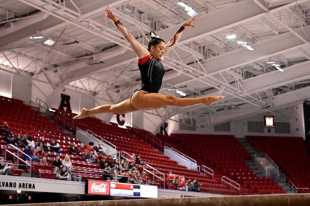 Sophomore gymnast Gabrielle Diaz performs a leap on the balance beam during NC State&#8217;s Red and White Exhibition meet at Reynolds Coliseum on Friday, Dec. 17, 2021. Diaz and her teammates on the white team beat the red team 10-7.