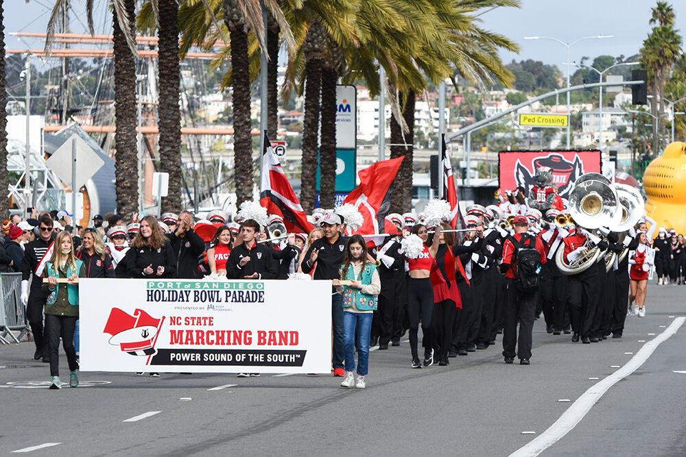 The NC State Marching Band, cheerleaders, and Mr. Wuf take part in the Holiday Bowl Parade in San Diego on Tuesday, Dec. 28, 2021. The Holiday Bowl was to host the game of NC State versus UCLA in Petco Park. It was canceled due to the COVID outbreak with UCLA players.
