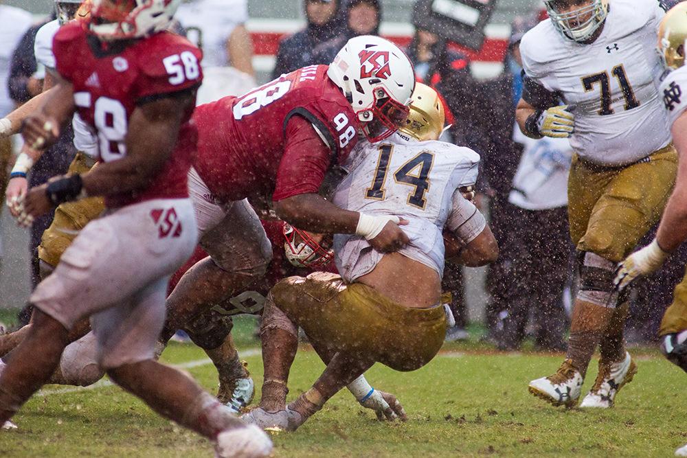 Junior defensive tackle B.J. Hill&#160;tackles Notre Dame's quarterback. Hill ended the game with four tackles and two fumble recoveries. NC State fought hard in the trenches for a 10-3 win during Hurricane Matthew on Oct. 8, 2016 in Carter-Finley Stadium.