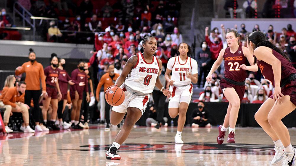 Sophomore guard Diamond Johnson dribbles down the court past Virginia Tech defenders at Reynolds Coliseum on Sunday, Jan. 23, 2022. The Wolfpack beat the Hokies 51-45.