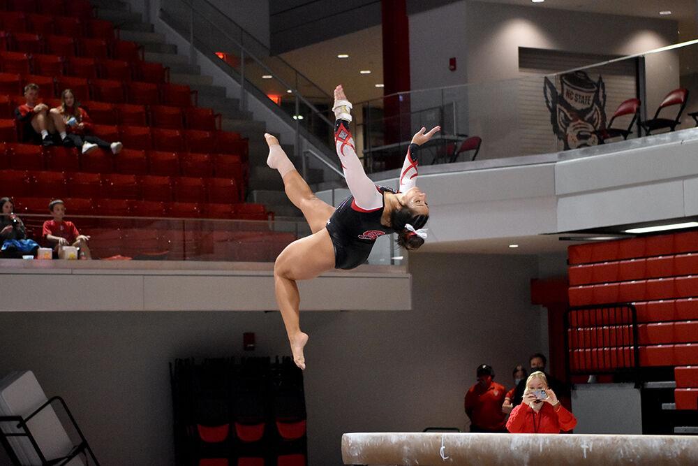 Junior gymnast Alexis Ortega dismounts the balance beam during NC State&#8217;s Red and White Exhibition meet at Reynolds Coliseum on Friday, Dec. 17, 2021. This preseason meet wrapped with the white team beating the red team 10-7.