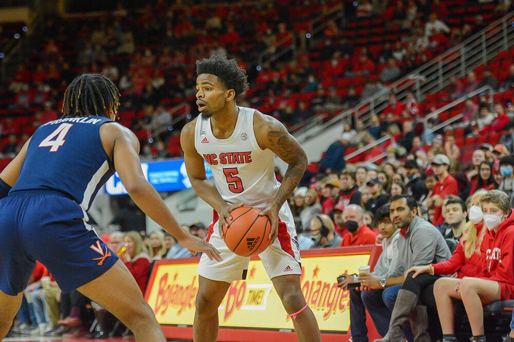 Redshirt-senior guard Thomas Allen searches for a teammate to pass to during the game against Virginia on Saturday, Jan. 22, 2022 at PNC Arena. Allen made two assists throughout the game. NC State beat Virginia 77-63.