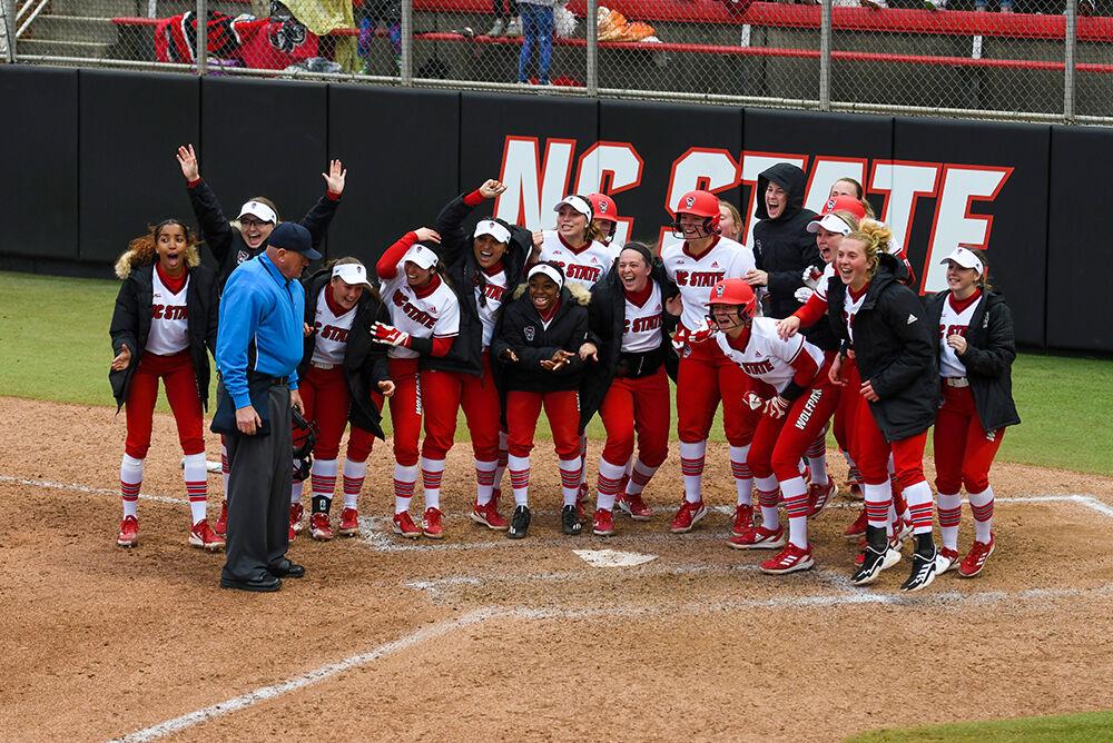 The entire team waits for freshman infielder Maddy Schmeiser after she hits the home run that ended the game against Central Connecticut State on Saturday, Feb. 26, 2022 at Dail Softball Stadium. The Wolfpack won the game 13-3.