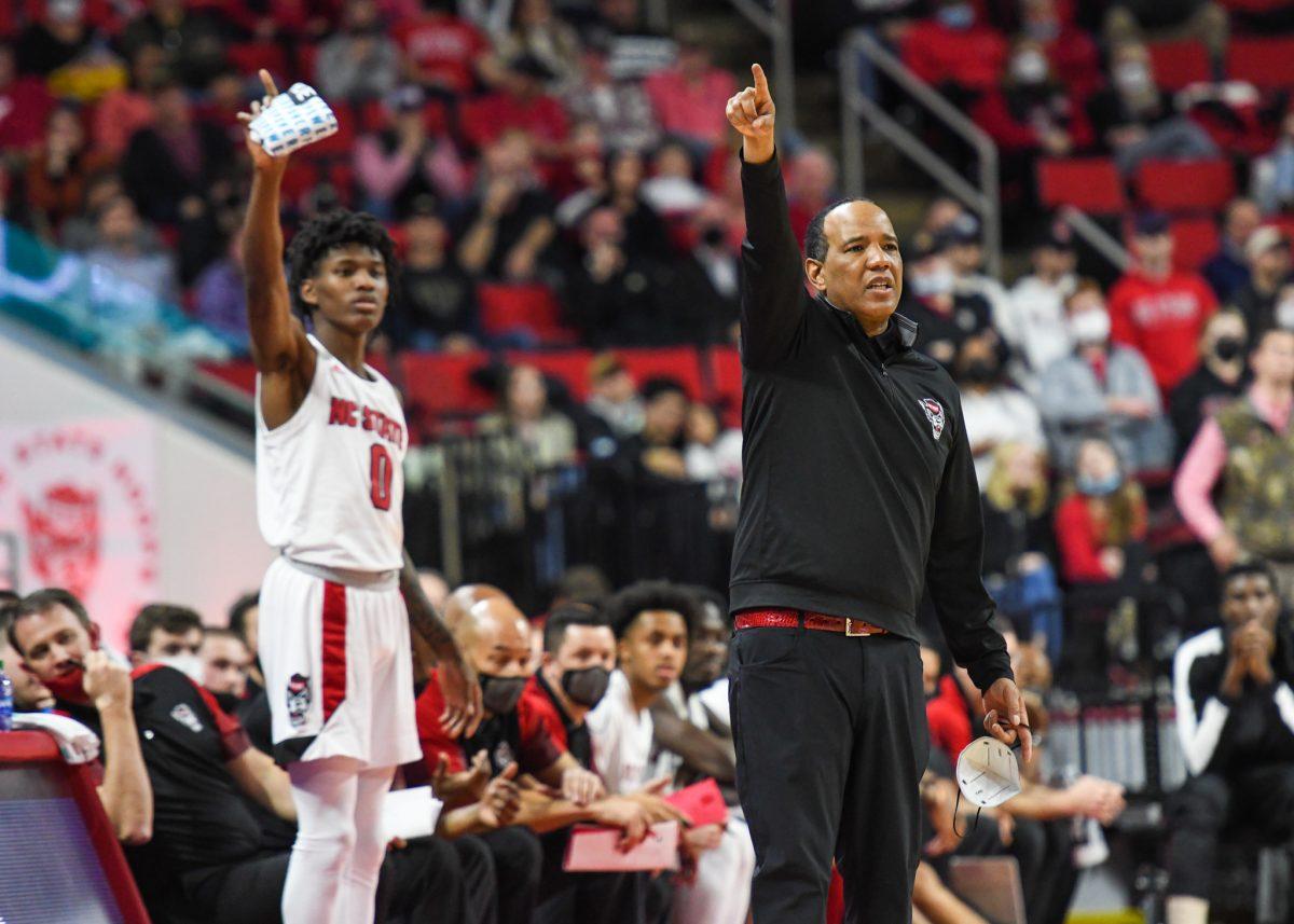 Head coach Kevin Keatts and freshman guard Terquavion Smith mirror each other while trying to help the Wolfpack's defensive effort against the Wake Forest Demon Deacons on Wednesday, Feb. 9, 2022 in PNC Arena. The Wolfpack lost to the Demon Deacons 69-51.