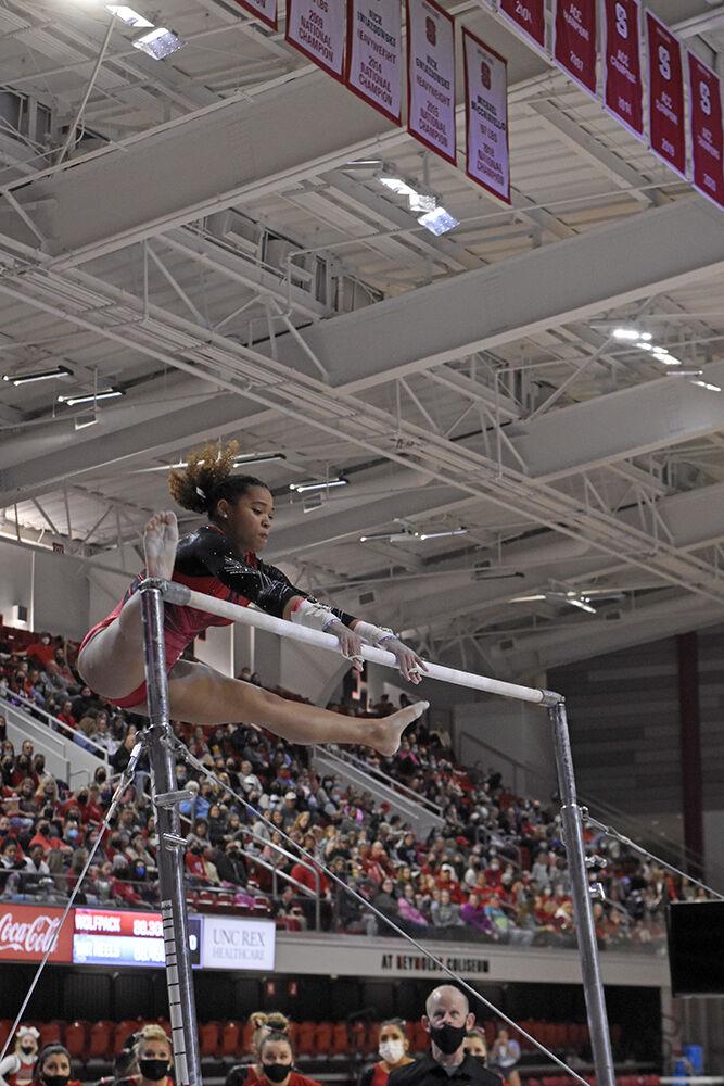 Sophomore gymnast Carina Jordan performs a release on the uneven bars at NC State&#8217;s meet against UNC at Reynolds Coliseum on Saturday, Feb. 19, 2022. Jordan scored 9.800 on the uneven bars. NC State lost UNC 196.625 to 196.350.