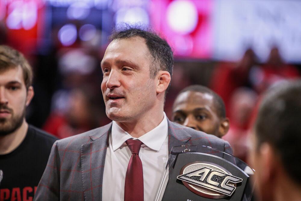 NC State head coach Pat Popolizio smiles as he receives the ACC championship trophy following NC State's 21-10 win over Virginia Tech in Reynolds Coliseum on Sunday, Feb. 20, 2022.
