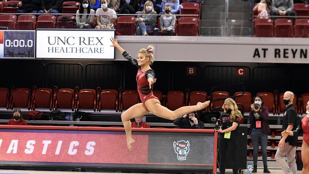 Graduate gymnast Nicole Webb performs a jump on the floor event during the meet against UNC on Saturday, Feb. 19, 2022 at Reynolds Coliseum. Webb received a score of 9.800 on the event. The Wolfpack lost to the Tar Heels 196.625 to 196.350.