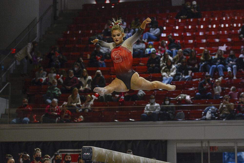 Graduate student gymnast Nicole Webb leaps on the balance beam during the quad meet against New Hampshire, George Washington and William &amp; Mary in Reynolds Coliseum on Saturday, Jan. 29, 2022. The Wolfpack placed second place behind New Hampshire with a score of 195.250.