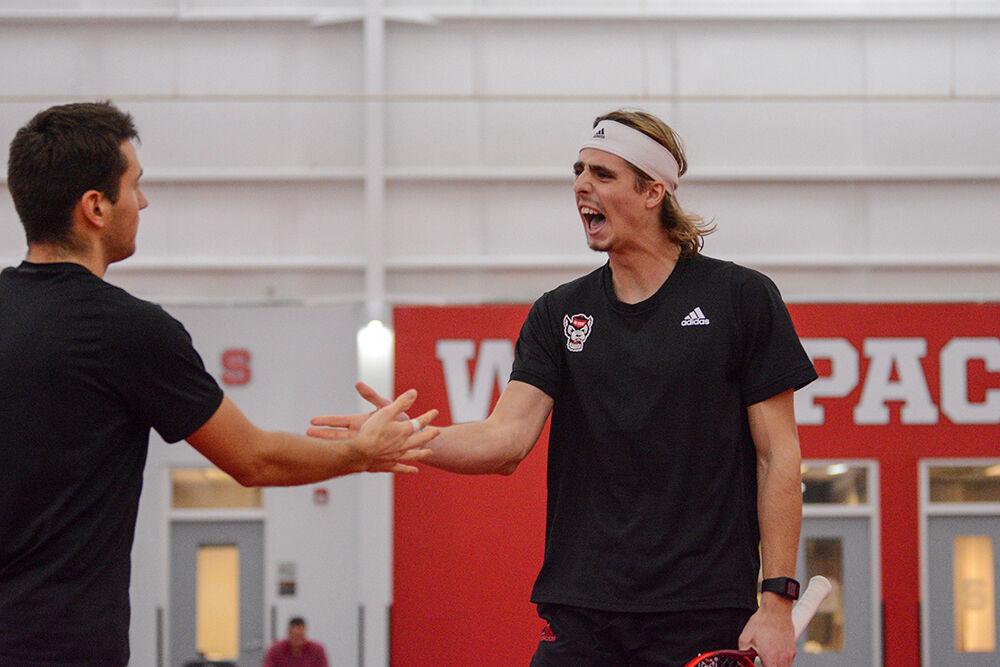 Junior Robin Catry, right, celebrates a point with doubles partner sophomore Luca Staeheli, left, during the men's tennis match against Georgia in the J. W. Isenhour Tennis Center on Friday, Feb. 4, 2022.&#160;NC State lost to Georgia 4-3.