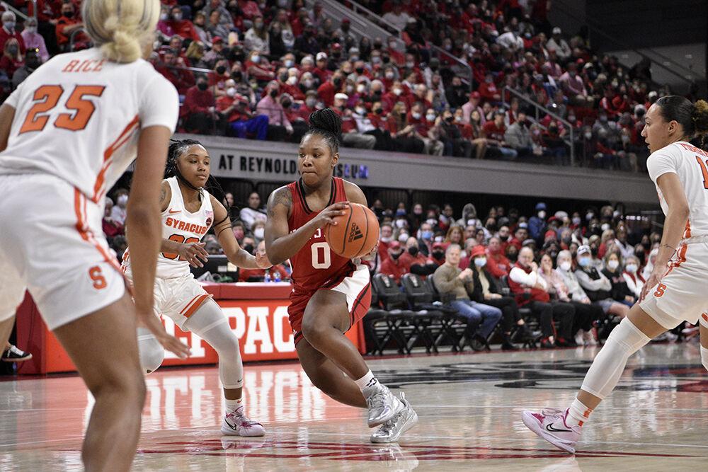 Sophomore guard Diamond Johnson dribbles away from Syracuse defenders at Reynolds Coliseum on Sunday, Feb. 20, 2022. Johnson scored six points and had three rebounds during the game. NC State beat Syracuse 95-53.