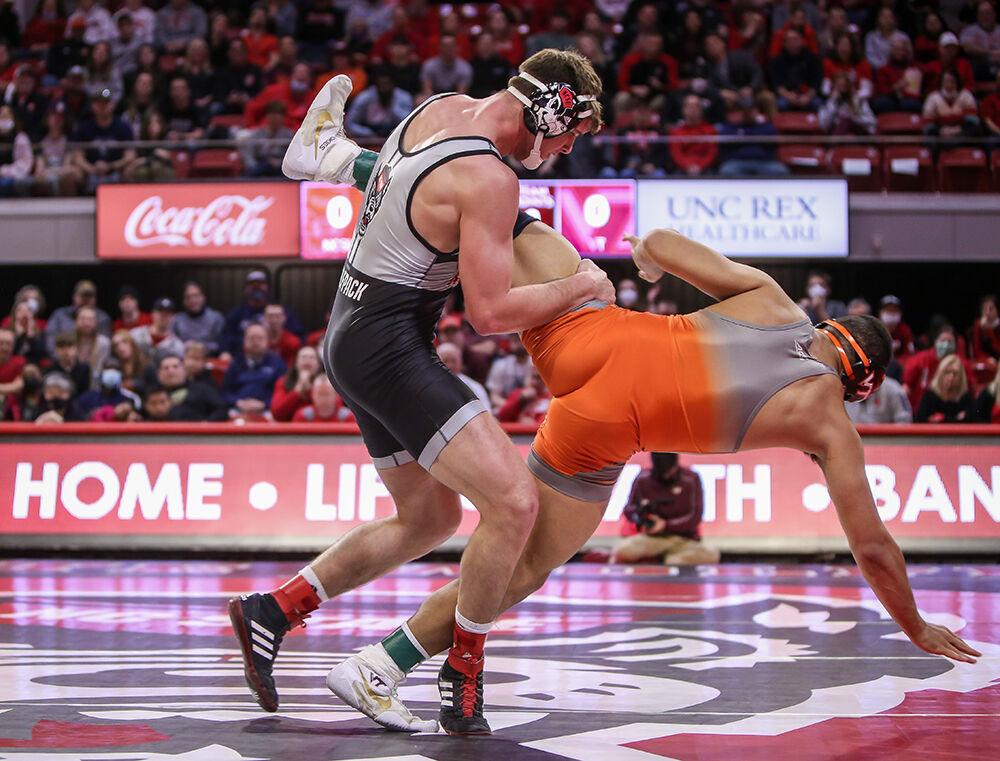 NC State freshman Isaac Trumble scores a takedown on Virginia Tech's Dakota Howard during his 6-0 victory in their 197-pound match. NC State beat Virginia Tech 21-10 in a wrestling match in Reynolds Coliseum on Sunday, Feb. 20, 2022.