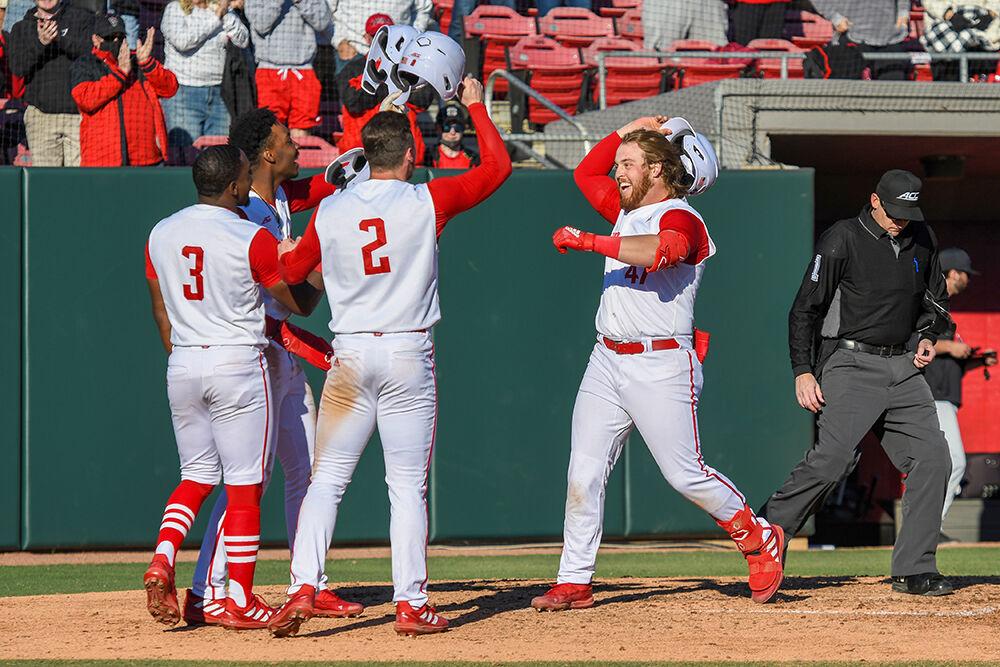 Freshman infielder Tommy White rejoins senior center fielder Devonte Brown, sophomore infielder LuJames Groover III and sophomore outfielder Noah Soles after hitting a grand slam in the game against Evansville on Saturday, Feb. 19, 2022 at Doak Field. NC State won the game with a final score of 6-4.