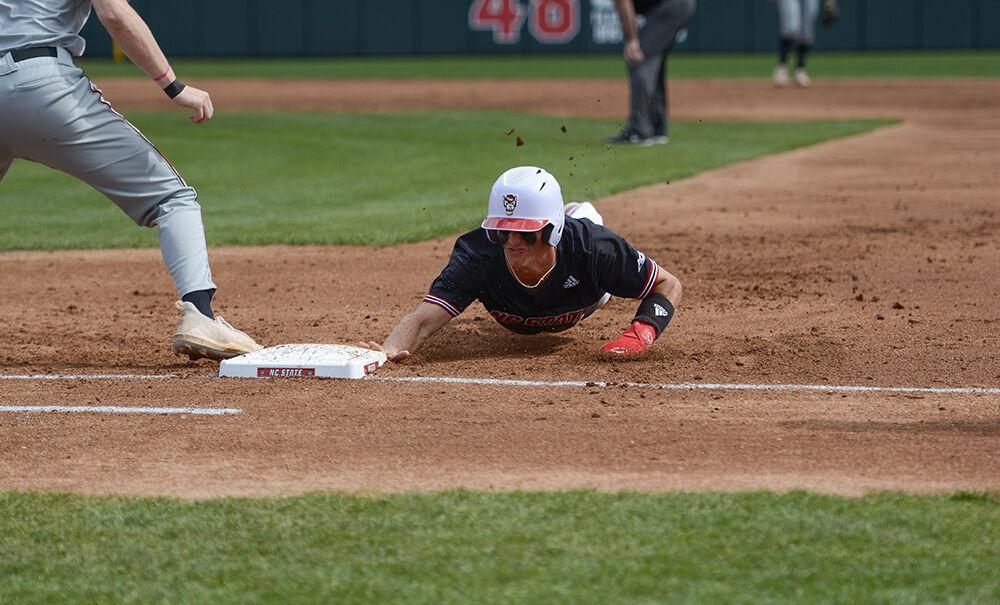 Redshirt junior infiielder Josh Hood dives back to first during the game against Northeastern on Sunday, Mar. 6, 2022 in Doak Field at Dail Park.&#160;The Wolfpack lost to the Huskies 6-0 and lost the series 3-0.