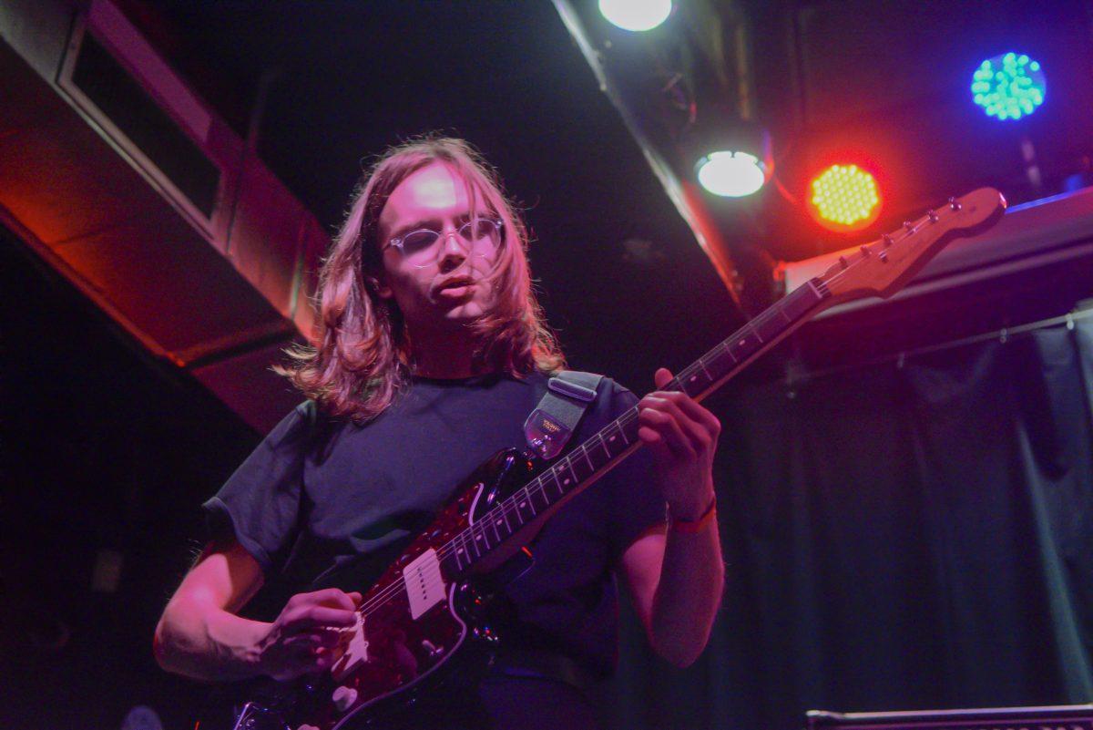 Sweet Home guitarist Kelly Bridges strums the guitar during the first night of Double Barrel Benefit at The Pour House Music Hall on Friday, March 12, 2022. Double Barrel Benefit is an annual concert fundraiser for WKNC 88.1.