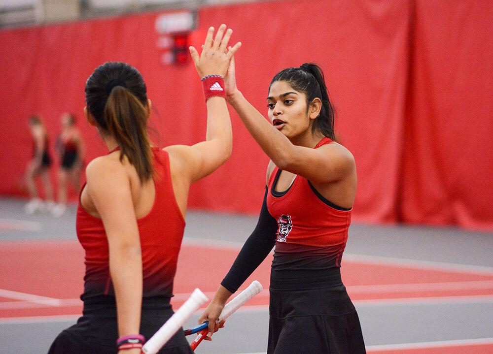 Senior Sara Nayar high-fives her doubles partner freshman Priska Nugroho during their doubles match against the University of South Carolina in J.W. Isenhour Tennis Center on Sunday, Feb. 6. 2022. Nayar and Nugroho won their doubles set 6-1 contributing to the Wolfpack's 7-0 defeat of the Gamecocks.