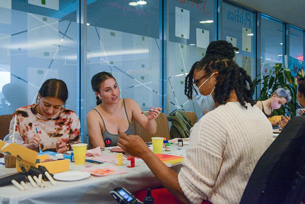 Natalie Locklear, a first-year in biochemistry, Alaina Isaak, a first-year in nutrition, and Alexus Smith, a graduate in English, paint together during the Women's Center event called "I'm Every Woman Interactive Storyteling Workshop" on Friday, March 25, 2022.&#160;