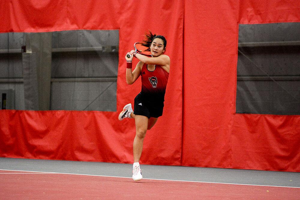 Freshman Priska Nugroho follows through after a backhand swing during her singles match against the University of South Carolina in J.W. Isenhour Tennis Center on Sunday, Feb. 6. 2022. Nugroho won her singles match 2-0. The Wolfpack beat the Gamecocks 7-0.
