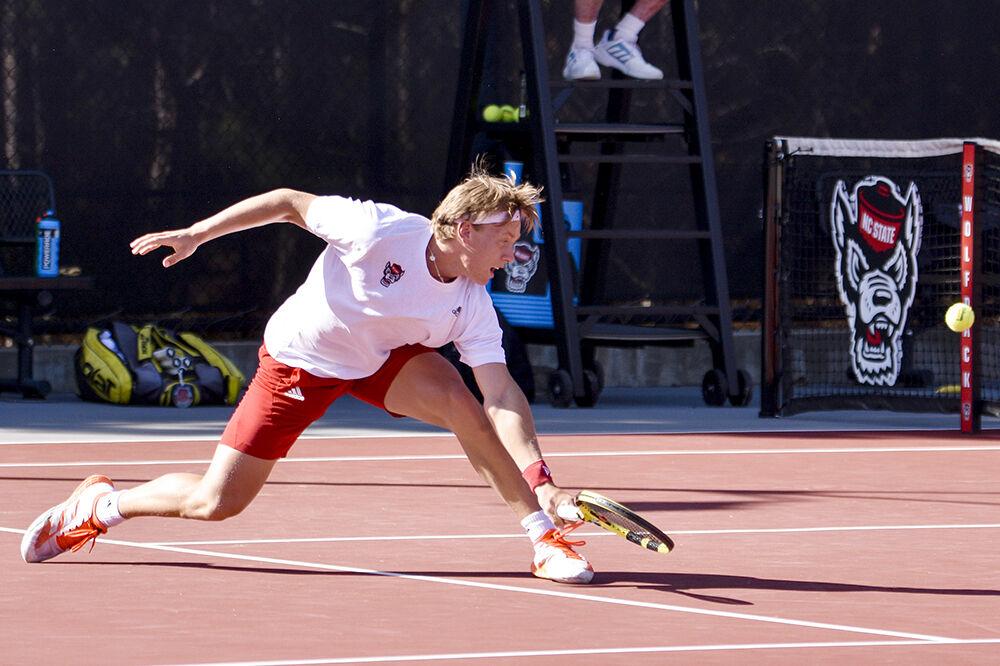Freshman Fons Van Sambeek lunges forward to return a ball during the match against Northwestern at J.W. Isenhour Tennis Center on Monday, March 21, 2022. Van Sambeek secured a point in his singles match which led to a Wolfpack win 4-2.